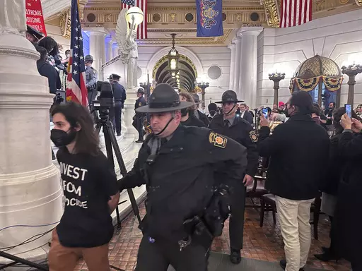 Police arrest some of about 200 people taken into custody on Monday, Feb. 5, 2024, in the Rotunda of the State Capitol in Harrisburg, Pennsylvania. The arrests shut down a demonstration against the state Treasury Department's investment of about $56 million in Israel bonds. The protest was organized by Jewish Voice for Peace, the Philly Palestine Coalition and the Pennsylvania Council on American-Islamic Relations. (AP Photo/Mark Scolforo)