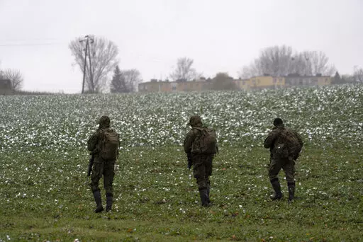 Polish soldiers search for missile wreckage in the field, near the place where a missile struck, in a farmland at the Polish village of Przewodow, near the border with Ukraine, Thursday, Nov. 17, 2022. (AP Photo/Vasilisa Stepanenko)