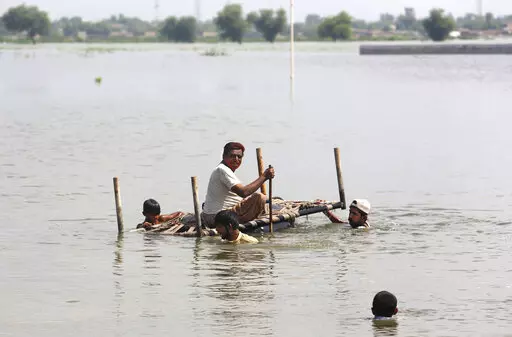 People use cot to salvage belongings from their nearby flooded home caused by heavy rain in Jaffarabad, a district of Pakistan's southwestern Baluchistan province, Saturday, Sep. 3, 2022. The homeless people affected by monsoon rains triggered devastating floods in Pakistan get enhancing international attention amid growing numbers of fatalities and homeless families across the country as the federal planning minister appealed the international community for immense humanitarian response for 33 