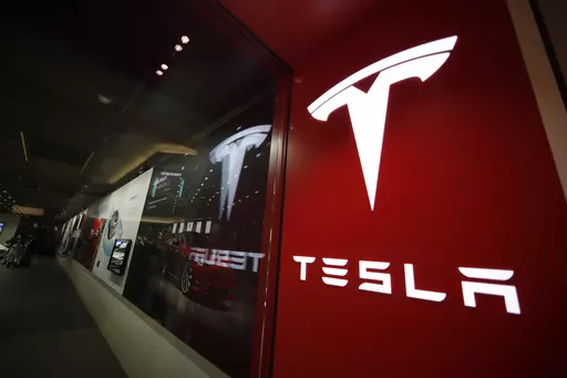 A sign bearing the Tesla company logo is displayed outside a Tesla store in Cherry Creek Mall in Denver, Feb. 9, 2019. Mohegan Sun, a casino and entertainment complex in Connecticut owned by the federally recognized Mohegan Tribe, announced on Wednesday, July 26, 2023, that Tesla will open a showroom with a sales and delivery center this fall on its sovereign property. By doing so, it circumvents laws in states that bar vehicle manufacturers from also being retailers in favor of the dealership m