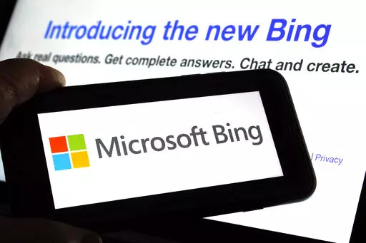 The Microsoft Bing logo and the website's page are shown in this photo taken in New York on Tuesday, Feb. 7, 2023. Microsoft is ready to take its new Bing chatbot mainstream — less than a week after making major fixes to stop the artificially intelligent search engine from going off the rails. The company said Wednesday, Feb. 22, it is bringing the new AI technology to its Bing smartphone app, as well as the app for its Edge internet browser. (AP Photo/Richard Drew)