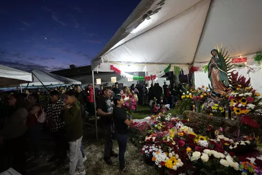 Devotees pray in front of a figure of the Virgin of Guadalupe during a festival celebrating one of several apparitions of the Virgin Mary witnessed by an indigenous Mexican man named Juan Diego in 1531, at St. Ann Mission in Naranja, Fla., Sunday, Dec. 10, 2023. For this mission church where Miami's urban sprawl fades into farmland and the Everglades swampy wilderness, it's the most important event of the year, both culturally and to fundraise to continue to minister to the migrant farmworkers i