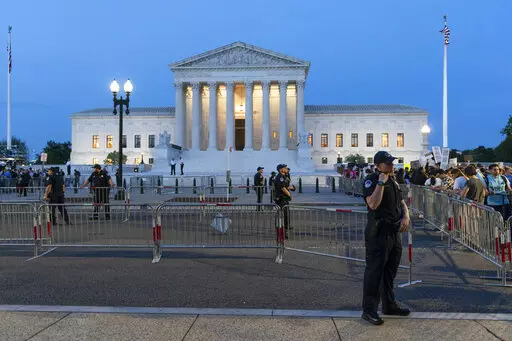 Demonstrators protest outside of the U.S. Supreme Court as law enforcement officers stand ready, May 3, 2022, in Washington. A leaked draft of a Supreme Court opinion overruling the landmark Roe v. Wade decision has thrust companies into the limelight on what’s arguably the most divisive issue in American politics. (AP Photo/Alex Brandon, File)