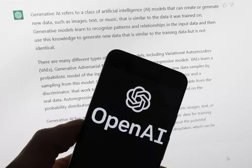The OpenAI logo is seen on a mobile phone in front of a computer screen displaying output from ChatGPT, Tuesday, March 21, 2023, in Boston. Are tech companies moving too fast in rolling out powerful artificial intelligence technology that could one day outsmart humans? That is the conclusion of a group of prominent computer scientists and other tech industry notables who are calling for a 6-month pause to consider the risks. Their petition published Wednesday, March 29, 2023, is a response to Sa