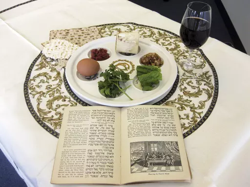 A 1936 Maxwell House Haggadah sits on a desk alongside a Seder plate on March 15, 2011, in New York. (AP Photo/Stace Maude, File)