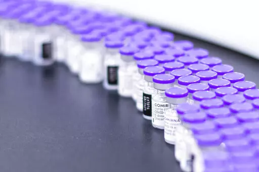 In this March 2021 photo provided by Pfizer, vials of the Pfizer-BioNTech COVID-19 vaccine are prepared for packaging at the company's facility in Puurs, Belgium. According to a study published Thursday. June 23, 2022 in the journal Lancet Infectious Diseases, nearly 20 million lives were saved by COVID-19 vaccines during their first year, but even more deaths could have been prevented if global targets had been reached. (Pfizer via AP)