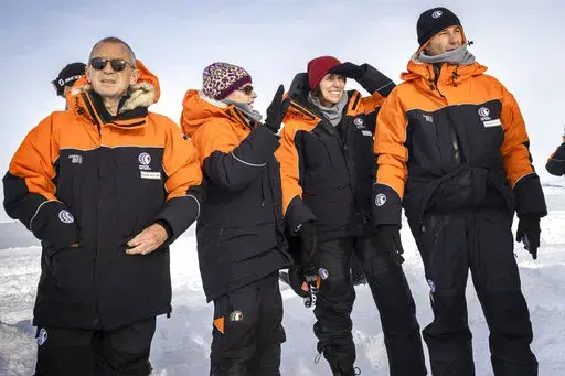 New Zealand Prime Minister Jacinda Ardern, second right, with her partner Clarke Gayford, right, are explained the sites by Antarctica New Zealand chief executive Sarah Williamson shortly after stepping off the plane in Antarctica, Wednesday, Oct. 26, 2022. Delegations from Russia and Ukraine are among those meeting in Australia this week to decide the future of Antarctica's pristine waters. (Mike Scott/NZ Herald/Pool via AP)