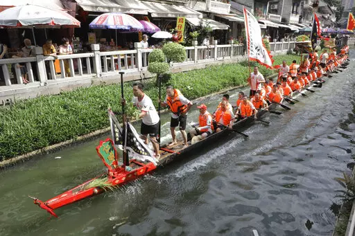 Dragon boat participants from Panting village row along a canal in the historic Lychee Bay scenic area in Guangzhou in southern China's Guangdong Province, Friday, June 3, 2022. Dragon boat races returned in parts of China on Friday for the first time since the outbreak of the pandemic in late 2019, as restrictions are lifted along with a major drop in COVID-19 cases. (AP Photo/Caroline Chen)