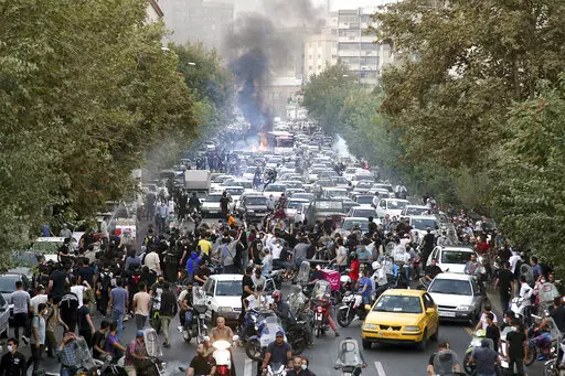 In this photo taken by an individual not employed by the Associated Press and obtained by the AP outside Iran, protesters chant slogans during a protest over the death of a woman who was detained by the morality police, in downtown Tehran, Iran, Sept. 21, 2022. (AP Photo, File)
