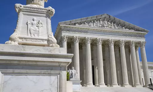 The U.S. Supreme Court is seen, with a carving of Justice in the foreground, April 19, 2023, in Washington. A Black Ohio woman who miscarried in her bathroom has been charged with abuse of a corpse and awaits grand jury action. Her case has sparked a national firestorm over the plight of pregnant women, especially women of color, following the U.S. Supreme Court’s decision to overturn Roe v. Wade. (AP Photo/Jacquelyn Martin, File)