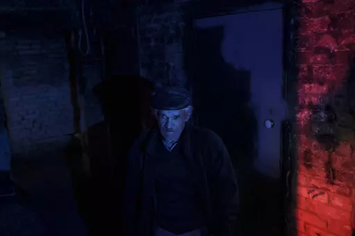 A resident stands inside a basement used as a bomb shelter during Russian attacks in a village recently retaken by Ukrainian forces near Kharkiv, Ukraine, Saturday, April 30, 2022. (AP Photo/Felipe Dana)