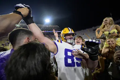 LSU offensive lineman Bo Bordelon (89) celebrates with LSU fans after they rushed the field after the team's overtime victory against Mississippi in an NCAA college football game in Baton Rouge, La., Saturday, Oct. 12, 2024. (AP Photo/Matthew Hinton)