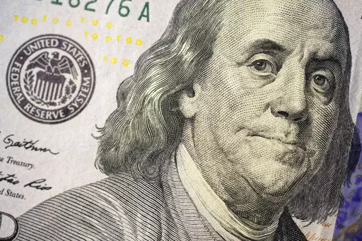 The likeness of Benjamin Franklin is seen on a U.S. $100 bill, Wednesday, Feb. 22, 2023, in Marple Township, Pa. If you are concerned you may be laid off, start saving. It's crucial to start building an emergency fund even when you feel secure at your job but especially if you think you might lose it. (AP Photo/Matt Slocum)