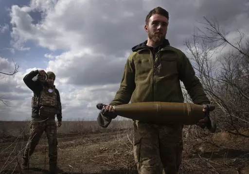 Ukrainian soldiers carry shells to fire at Russian positions on the front line, near the city of Bakhmut, in Ukraine's Donetsk region, on March 25, 2024. Approval by the U.S. House of a $61 billion package for Ukraine puts the country a step closer to getting an infusion of new firepower. But the clock is ticking. Russia is using all its might to achieve its most significant gains since the invasion by a May 9 deadline. (AP Photo/Efrem Lukatsky, File)