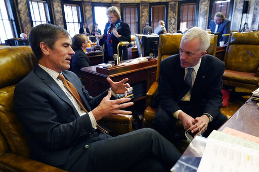 Briggs Hopson, R-Vicksburg, left, and David Blount, D-Jackson confer following adjournment at the Mississippi State Capitol in Jackson, Miss., Tuesday, Jan. 4, 2022. Lawmakers of both chambers met quickly and adjourned on the first day the 90-day session. (AP Photo/Rogelio V. Solis)
