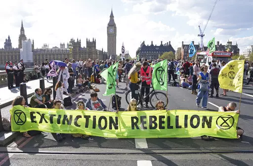 Demonstrators take part in an Extinction Rebellion protest on Westminster Bridge in London, Friday, April 15, 2022. Climate-change protesters have snarled traffic by blocking four London bridges. Cars and red double-decker buses backed up along roads as hundreds of Extinction Rebellion activists occupied London’s Waterloo, Blackfriars, Lambeth and Westminster bridges, calling for an end to new fossil fuel investments. (Stefan Rousseau/PA via AP)