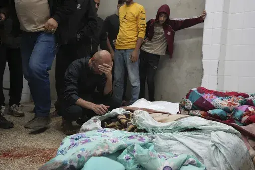 Palestinians mourn over relatives killed in an Israeli bombardment in Nuseirat, central Gaza, as they stand in a hospital morgue in Deir al-Balah, Gaza Strip, Wednesday, Nov. 20, 2024. (AP Photo/Abdel Kareem Hana)