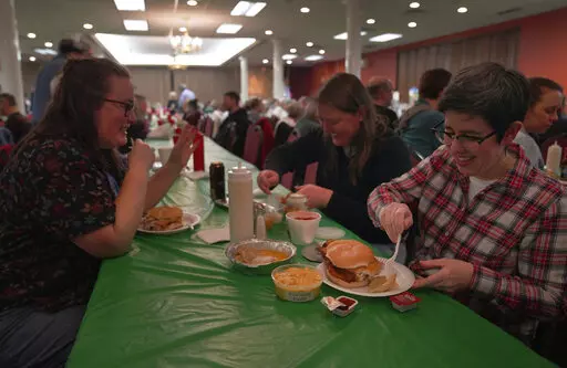 From left, Laura Kuster, Miranda Crotsley, and Hollen Barmer eat fish sandwiches, homemade perogies, and macaroni and cheese at the St. Maximilian Kolbe Catholic Church fish fry in the West Homestead neighborhood of Pittsburgh, on Friday, Feb. 24, 2023. To innovate the age-old tradition of fish fries, Barmer and volunteers from Code for Pittsburgh created the "Pittsburgh Lenten Fish Fry Map," an online interactive map that locates and documents active fish fries from year to year across Western 