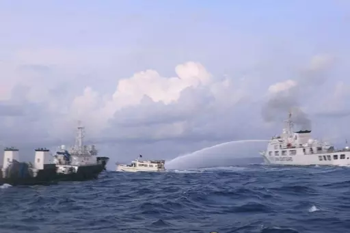 In this handout photo provided by the Philippine Coast Guard, a Chinese Coast Guard ship uses water cannons on Philippine navy-operated supply boat M/L Kalayaan as it approaches Second Thomas Shoal, locally known as Ayungin Shoal, in the disputed South China Sea on Sunday Dec. 10, 2023. The Chinese coast guard targeted Philippine vessels with water cannon blasts Sunday and rammed one of them, causing damage and endangering Filipino crew members off a disputed shoal in the South China Sea, just a