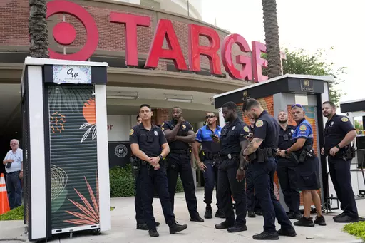Police officers stand outside of a Target store as a group of people across the street protest against Pride displays in the store on June 1, 2023, in Miami. Target confirmed that it won't be carrying its LGBTQ+ merchandise for Pride month in June, 2024, in some stores after the discount retailer received backlash last year for its assortment. (AP Photo/Lynne Sladky, File)