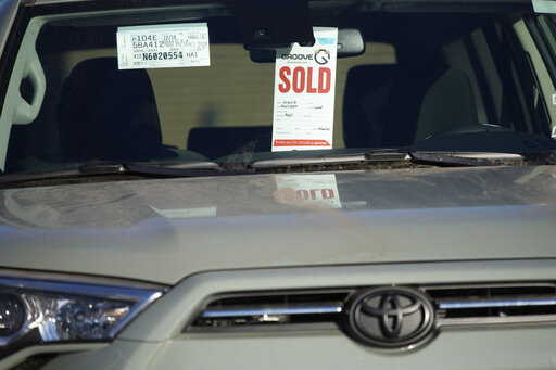 A sold tag hangs from the inside rear-view mirror of a 2022 4Runner sports-utility vehicle as it sits in an empty storage lot at a Toyota dealership Sunday, Feb. 27, 2022, in Englewood, Colo. (AP Photo/David Zalubowski, File)