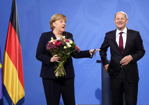 New elected German Chancellor Olaf Scholz, right, has given flowers to former Chancellor Angela Merkel during a handover ceremony in the chancellery in Berlin, Wednesday, Dec. 8, 2021. (Photo/Markus Schreiber)