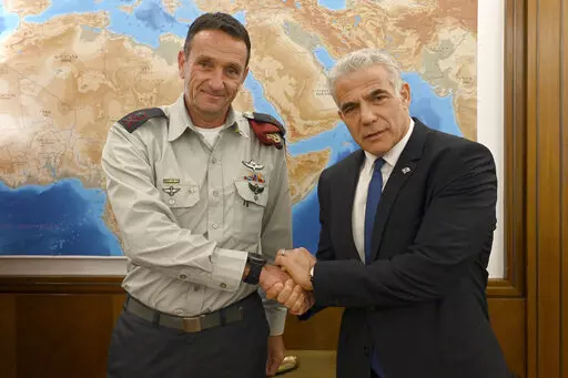 In this photo provided by the Government Press Office, Israeli Prime Minister Yair Lapid, right, poses for a photo with Israel's next military chief Maj. Gen. Herzi Halevi in Jerusalem, Aug. 3, 2022. For the first time, a Jewish West Bank settler is set to take the reigns as chief of staff of Israel's military, the enforcer of the country's 55-year-old military occupation. Halevi’s rise caps the decades-long transformation of the settler movement from a small group of religious ideologues to a
