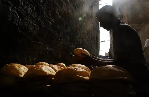 A baker stacks loaves of Egyptian traditional "baladi" flatbread outside a bakery, in the Old Cairo district of Cairo, Egypt, Sept. 8, 2022. For decades, millions of Egyptians have depended on the government to keep basic goods affordable. But a series of shocks to the global economy and Russia's invasion of Ukraine have endangered the social contract in the Middle East's most populous country, which is also the world's biggest importer of wheat. It is now grappling with double-digit inflation a
