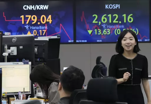 A currency trader passes by a screen showing the Korea Composite Stock Price Index (KOSPI), top right, at the foreign exchange dealing room of the KEB Hana Bank headquarters in Seoul, South Korea, Monday, June 19, 2023. Asian stock markets followed Wall Street lower Monday after the top U.S. and Chinese diplomats agreed to cooperate during a meeting held at a time of friction over an array of conflicts. (AP Photo/Ahn Young-joon)