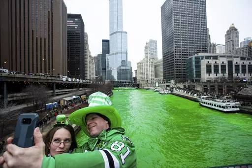 Stacey Peterson and Kevin McGuire take a selfie in front of the green Chicago River to celebrate St. Patrick's Day, Saturday, March 17, 2018. The Chicago River has been dyed a bright shade of green, kicking off the city's St. Patrick's Day festivities. The day honoring the patron saint of Ireland is a global celebration of Irish heritage. And nowhere is that more so than in the United States, where parades take place in cities around the country and all kinds of foods and drinks are given an eme