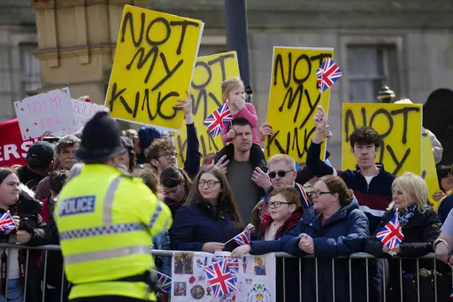 Protestors wait for the arrival of King Charles III and Camilla, the Queen Consort to visit Liverpool Central Library, and to officially mark the Library's twinning with Ukraine's first public Library, the Regional Scientific Library in Odesa, in Liverpool, England, Wednesday, April 26, 2023. There will be dissenters among the cheering crowds when King Charles III travels by gilded coach to his coronation. More than 1,500 protesters will be dressed in yellow for maximum visibility and they plan 
