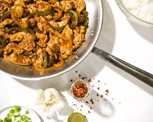 This image released by Milk Street shows a recipe for Stir-fried Hoisin Chicken and Bell Peppers. (Milk Street via AP)