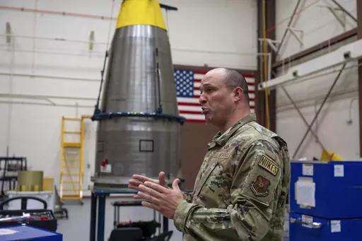 In this image provided by the U.S. Air Force, Chief Master Sgt. Andrew Zahm speaks in front of the top of a Minuteman III intercontinental ballistic missle shroud at F.E. Warren Air Force Base, Wyo., Aug. 16, 2023. Zahm has worked on the military's nuclear missile mission for 21 years. The increased workload of maintaining old missiles with fewer people has made it harder to convince younger troops to stay, especially because with their critical skillset they could make much more money in the pr