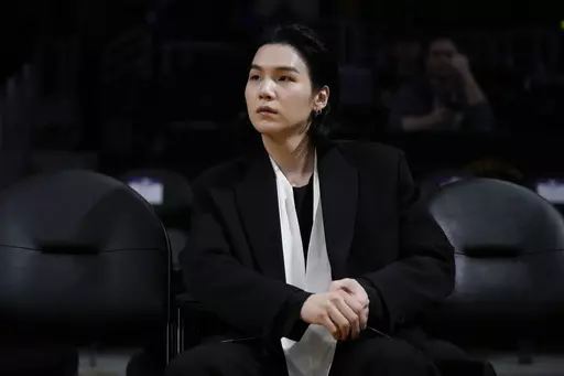 BTS member Suga attends an NBA basketball game between the Los Angeles Lakers and the Dallas Mavericks on Jan. 12, 2023, in Los Angeles. Suga has become the third member of BTS to begin South Korea’s compulsory military service. BTS' label, Big Hit Music, said in a statement on Monday, Aug. 7, 2023, that Suga "has initiated the military enlistment process by applying for the termination of his enlistment postponement.” (AP Photo/Jae C. Hong, File)