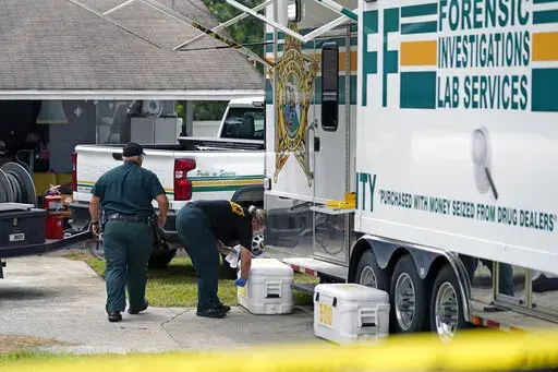 Officers from the Polk County Sheriff Department work outside Tuesday, Sept. 7, 2021, in Lakeland, Fla., at the home where a family of four was shot and killed. (AP Photo/John Raoux)