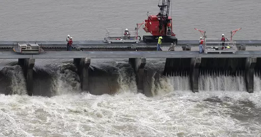 Workers open bays of the Bonnet Carre Spillway to divert rising water from the Mississippi River to Lake Pontchartrain, upriver from New Orleans, in Norco, La., May 10, 2019. Several local governments and business groups on the Mississippi Gulf Coast filed a lawsuit Monday, Jan. 22, 2024, saying that the U.S. Army Corps of Engineers' opening of the spillway in 2019 sent polluted fresh water from the Mississippi River into the Gulf of Mexico and killed bottlenose dolphins that live in saltwater. 