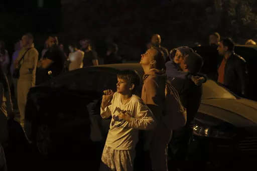 People look at a fire on the top of residential building following a drone attack, in Kyiv, Ukraine, Saturday, May 20, 2023. Russian air attacks have escalated to near-nightly raids over the last month. The attacks come at night, when most in Kyiv are sound asleep. The sirens wail across the Ukrainian capital, rousing bleary-eyed residents, who, after 15 months of war, have customized individual routines to cope with Russia’s latest air campaign. (AP Photo/Alex Babenko, File)