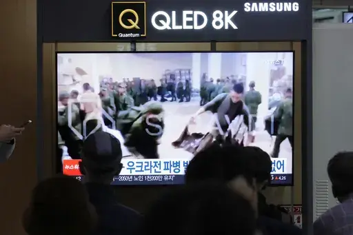 A TV screen at Seoul Railway Station in South Korea, on Oct. 21, 2024, shows an image of soldiers believed to be from North Korea standing in line to receive supplies from Russia. (AP Photo/Ahn Young-joon, File)