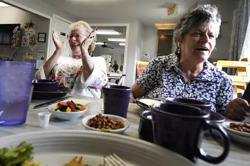 Debbie LaBarre, left, laughs while having breakfast, as part of the Meals on Wheels "Dine Out Club", with her sister, Suzanne Marchand, right, at the White Birch Cafe, Wednesday, Aug. 16, 2023, in Goffstown, N.H. In some states, programs that give struggling restaurants some of the federal and state money set aside to feed seniors have grown in popularity. The restaurants can provide balanced meals with more choices, flexible timing and a judgment-free setting that can help seniors get together 