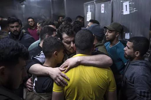 Mourners comfort each other in the morgue of Al-Shifa Hospital after Israeli airstrikes killed a dozen Palestinians in Gaza City, Tuesday, May 9, 2023. As Israeli warplanes pummel Gaza to avenge the Hamas attack, Palestinians say the military has largely unleashed its fury on civilians. (AP Photo/Fatima Shbair, File)