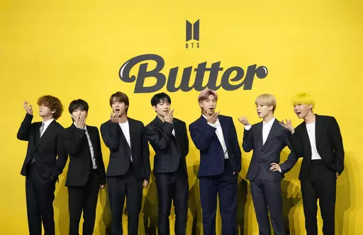 FILE- Members of South Korean K-pop band BTS, V, SUGA, JIN, Jung Kook, RM, Jimin, and j-hope from left to right, pose for photographers ahead of a press conference to introduce their new single "Butter" in Seoul, South Korea, Friday, May 21, 2021. Three members of the K-pop superstar group BTS have been infected with the coronavirus.  the Big Hit Entertainment agency says in a statement that RM and Jin were diagnosed with COVID-19 on Saturday evening. It earlier said another member, Suga, teste