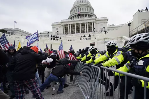 Violent insurrectionists loyal to then-President Donald Trump try to break through a police barrier, Wednesday, Jan. 6, 2021, at the Capitol in Washington. (AP Photo/Julio Cortez, File)