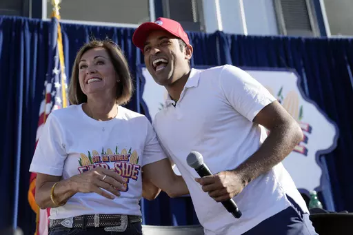 Republican presidential candidate businessman Vivek Ramaswamy laughs after taking part in a Fair-Side Chat with Iowa Gov. Kim Reynolds, left, at the Iowa State Fair Saturday, Aug. 12, 2023, in Des Moines, Iowa. (AP Photo/Jeff Roberson)