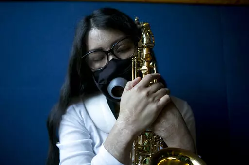 Maria Elena Ríos holds her saxophone at the end of a rehearsal at the National Autonomous University of Mexico music department, in Mexico City, Tuesday, Feb. 14, 2023. Ríos, 29, thought her career as a musician and her devotion to hersaxwas what ledherformer boyfriend and politician to hire the men who splashed acid into her faceand body, disfiguring her in 2019. Later, she learned that he simply couldn't accept that she had broken off their relationship. (AP Photo/Ginnette Riquelme)