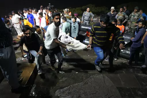 Volunteers carry a victim after a cable bridge across the Machchu river collapsed in Morbi town of western state Gujarat, India, Monday, Oct. 31, 2022. More than 400 people died in October in a series of crowd-related disasters in Asia that could have been prevented if authorities had acted differently. (AP Photo/Ajit Solanki, File)