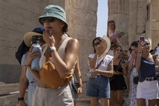 Tourists visit the ancient Acropolis hill during a heat wave in Athens, Greece, on July 21, 2023. Climate change is making heat waves crawl slower across the globe and last longer with higher temperatures over larger areas, a new study finds. (AP Photo/Petros Giannakouris, File)