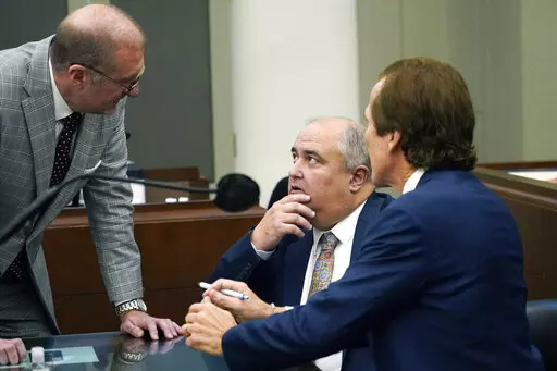 John Davis, former director of the Mississippi Department of Human Services, confers with defense attorneys Merrida Coxwell, right, and Charles Mullins, left, in Jackson, Miss., on Sept. 22, 2022. Davis pleaded guilty to state and federal charges in a conspiracy to misspend tens of millions of dollars that were intended to help needy families in one of the poorest states in the U.S. as part of the largest public corruption case in Mississippi history. (AP Photo/Rogelio V. Solis, File)