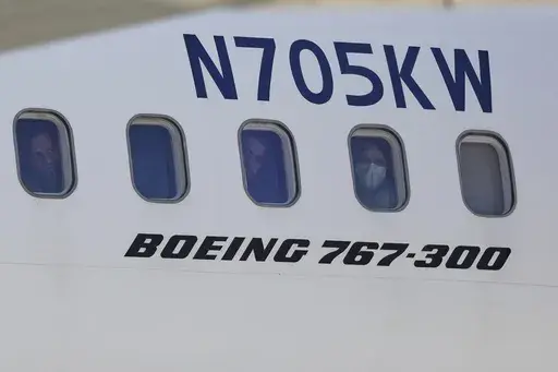 Venezuelan migrants deported from the United States peer through windows of an Eastern Airlines plane upon arriving at Simon Bolivar International Airport in Maiquetia, Venezuela, Sunday, March 30, 2025. (AP Photo/Cristian Hernandez)