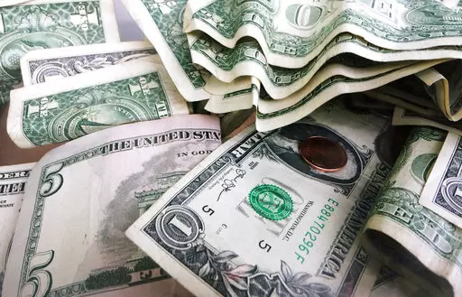 FILE- This Sept. 6, 2017, file photo shows a tip jar with one dollar and five dollar bills and a penny in New York. Millions of Americans deal with food, housing and general financial insecurity every year. Getting help can be tedious and time consuming, especially if you’re facing language barriers, don’t have reliable internet access or simply don’t have the bandwidth because you’re caring and providing for your family. Nonprofit organizations like 211.org and the National Low Income H