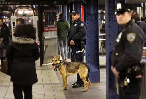 Police officers patrol in the passageway connecting New York City's Port Authority bus terminal and the Times Square subway station, Dec. 12, 2017. New York City plans to intensify a crackdown on subway fare-beating by sending at least 800 police officers specifically to keep watch on turnstiles, officials announced Monday, March 25, 2024. (AP Photo/Seth Wenig, File)